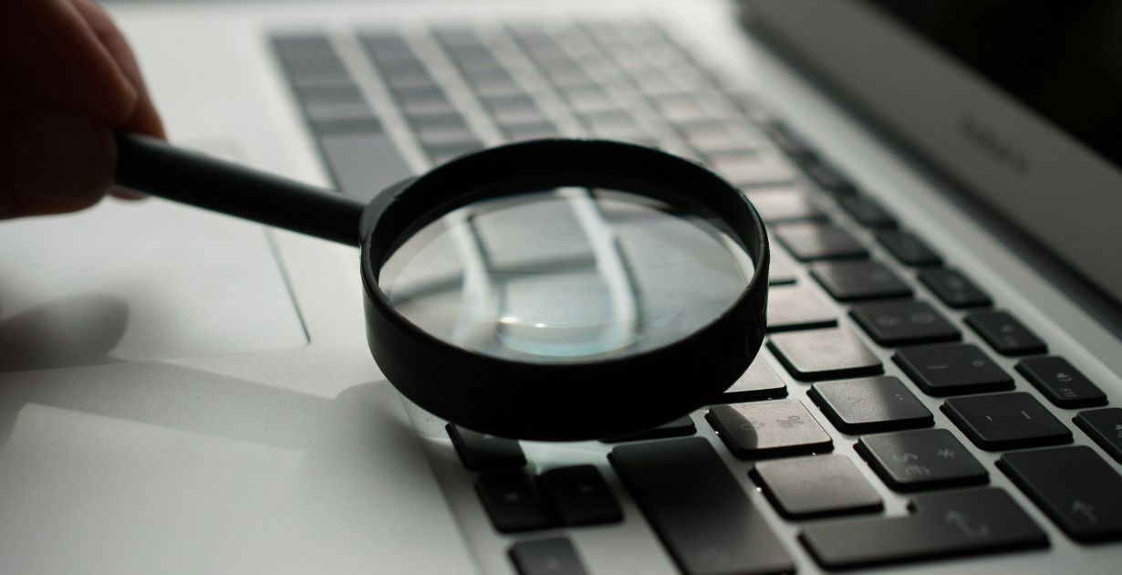 A person intently searching for hidden files on a laptop, focused on the screen with a thoughtful expression.