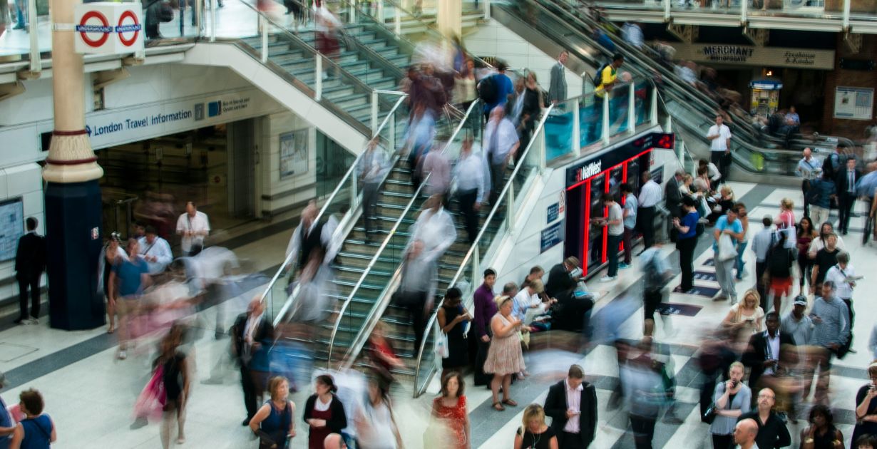 Blurry image of a crowd walking in a large building, symbolizing diverse website users for UX considerations.
