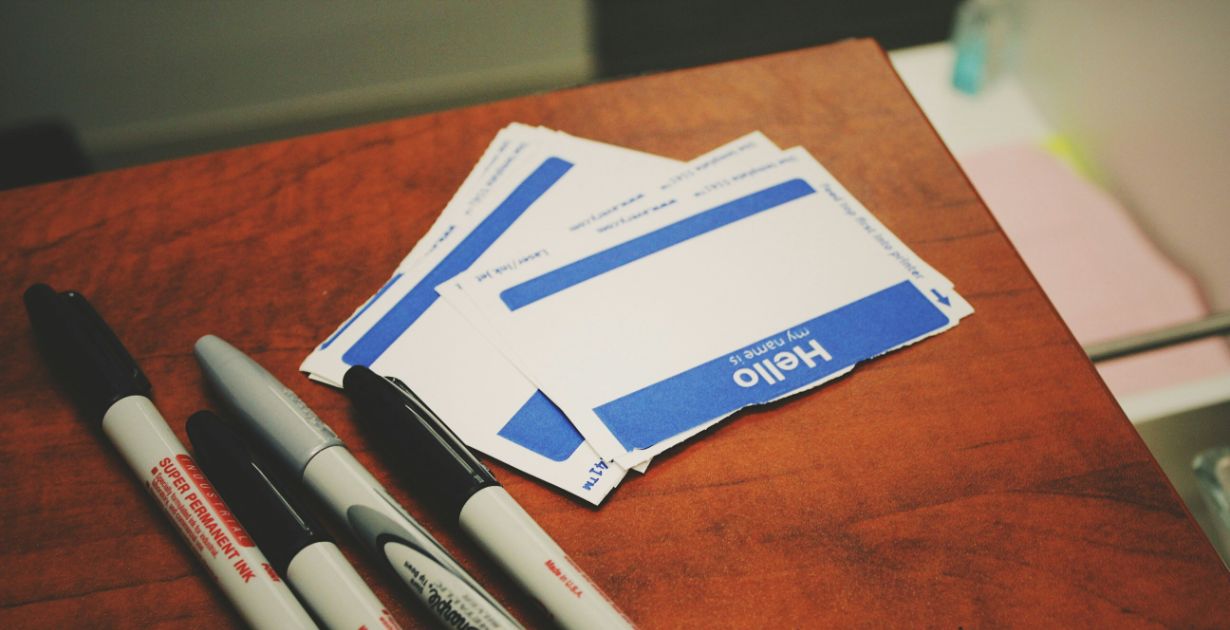 Name tags and markers on a wooden surface.