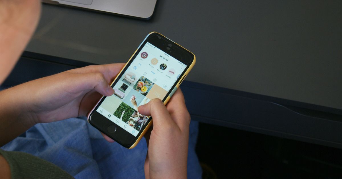 Person using a smartphone with a social media app open.