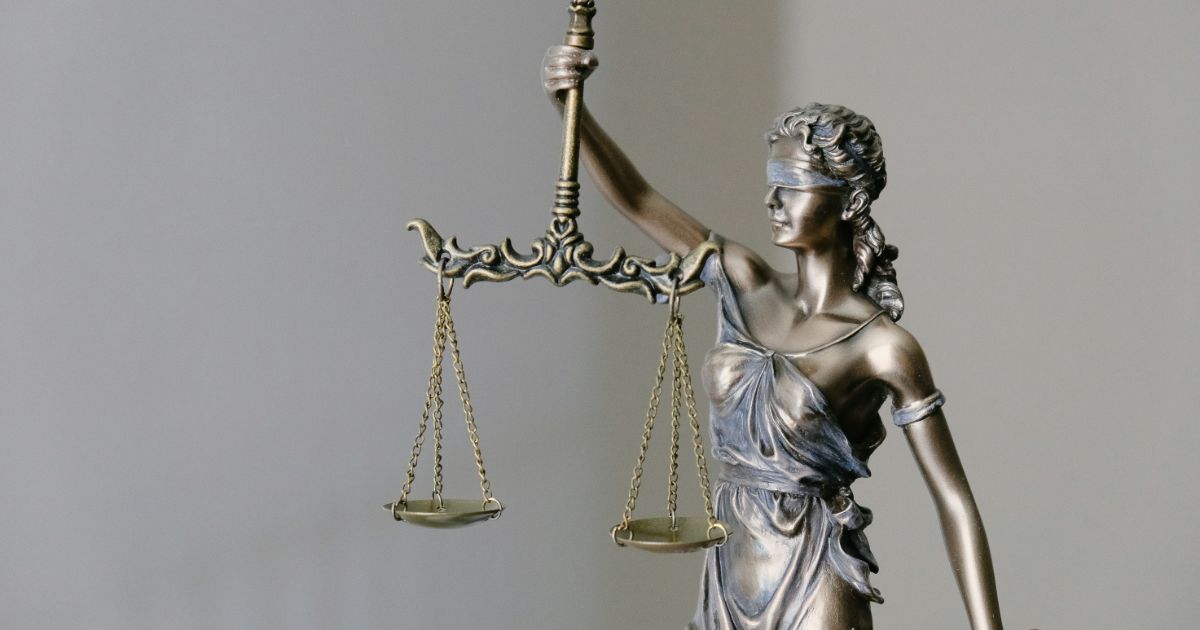 A statue of Lady Justice stands tall, holding a balanced scale, symbolizing fairness and the rule of law.