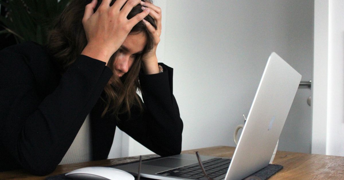 A woman sits at her desk, overwhelmed, contemplating her journey mapping for UX.