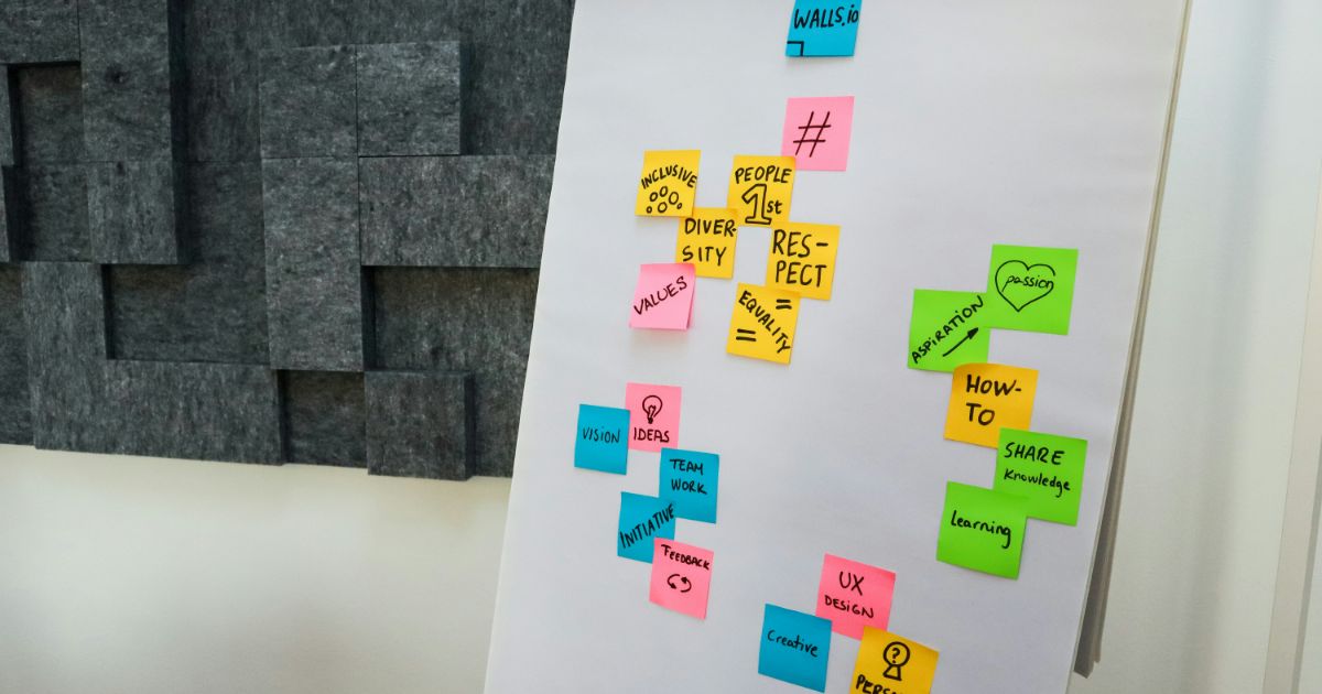A whiteboard filled with colorful sticky notes, showcasing various ideas and reminders organized for easy reference.