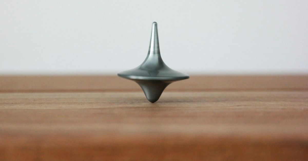 A sleek metal object rests elegantly on a rustic wooden table, showcasing a blend of modern design and natural warmth.
