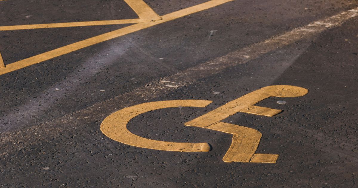 Handicapped parking sign displayed on the ground, highlighting the importance of inclusive design in public spaces.