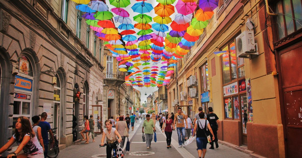A lively street scene with numerous individuals carrying umbrellas, highlighting Cross-Cultural UX Research.