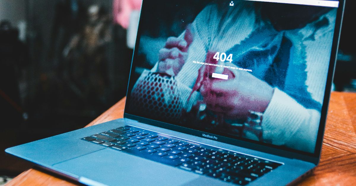 A laptop rests on a wooden table, showcasing a simple workspace setup and the Pratfall Effect in UX.