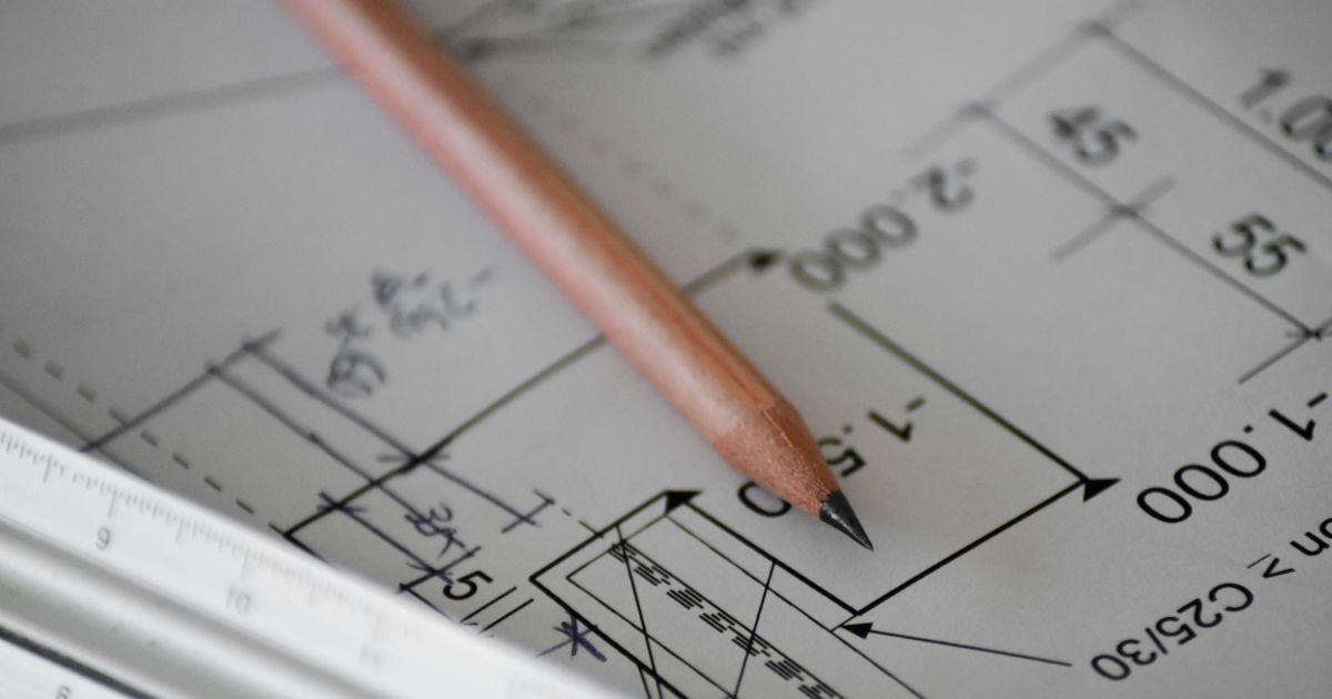 A sharpened pencil rests on a detailed blueprint, symbolizing design and planning in architecture or engineering representing information architecture for findability.