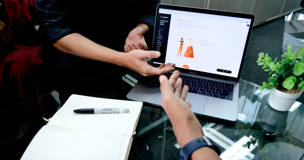 A person sitting at a desk, focused on a laptop while making an online purchase representing UX maturity benchmarking