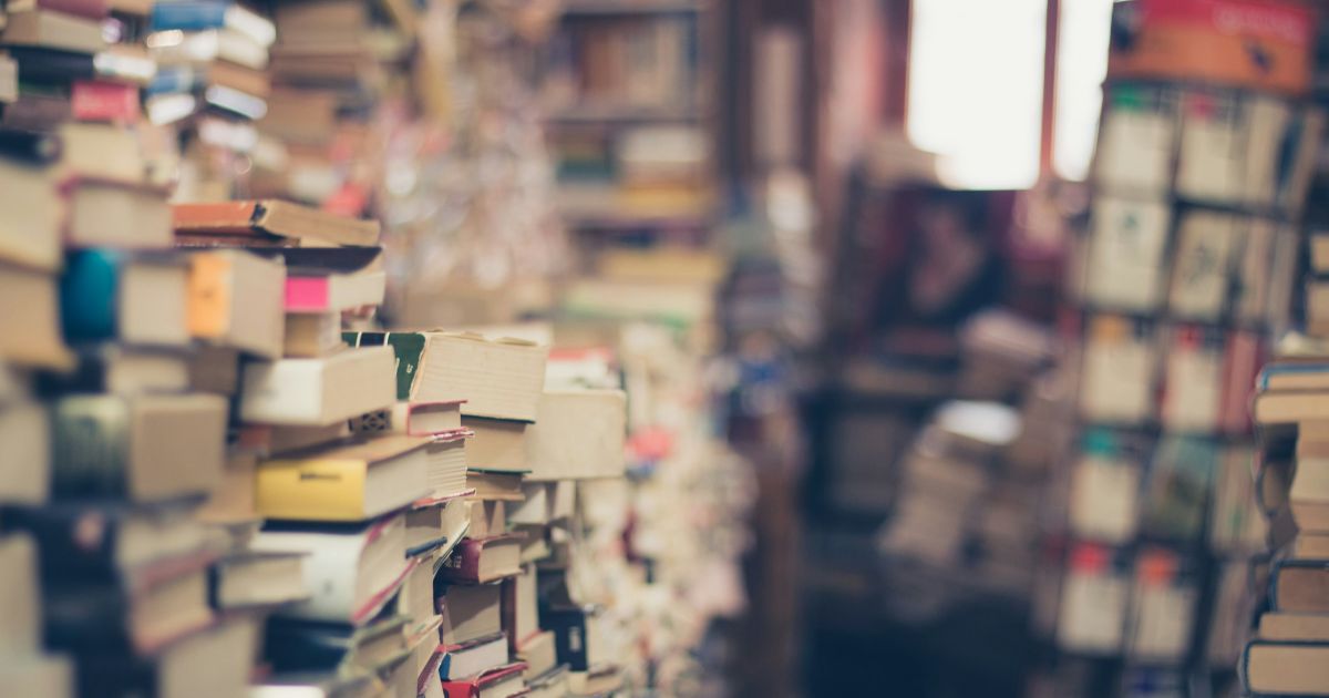 A stack of various books displayed in a cozy bookstore setting representing semantic search in information architecture.
