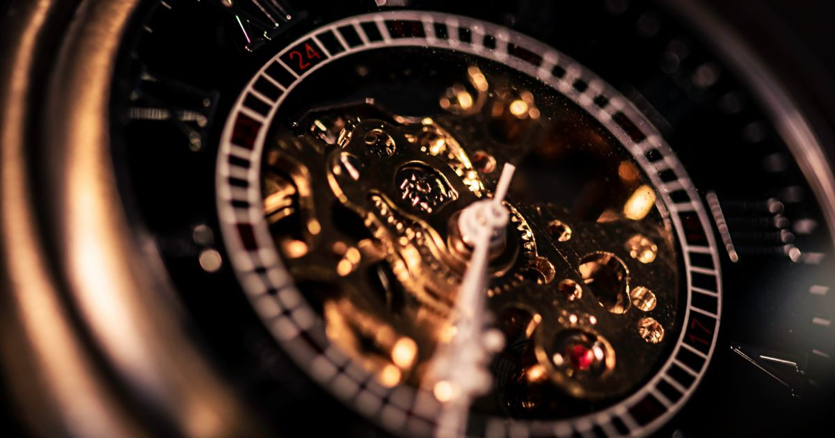 Close-up of a clock featuring a gold face, highlighting its intricate design and elegant details representing design for digital longevity.