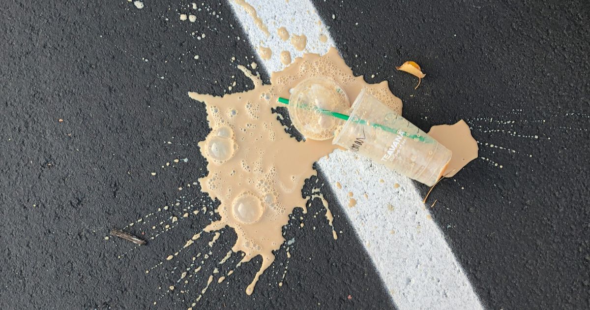 A coffee cup and a plastic bag are placed on the ground, illustrating the theme of UX for degradation.